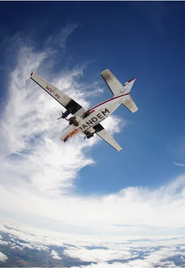 Avión JUMP-TANDEM OK-JUM visto desde abajo en el cielo azul, muy por encima de las nubes