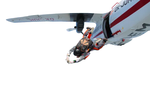 Tandem instructor and passenger diving out of the door of a white-and-red aircraft