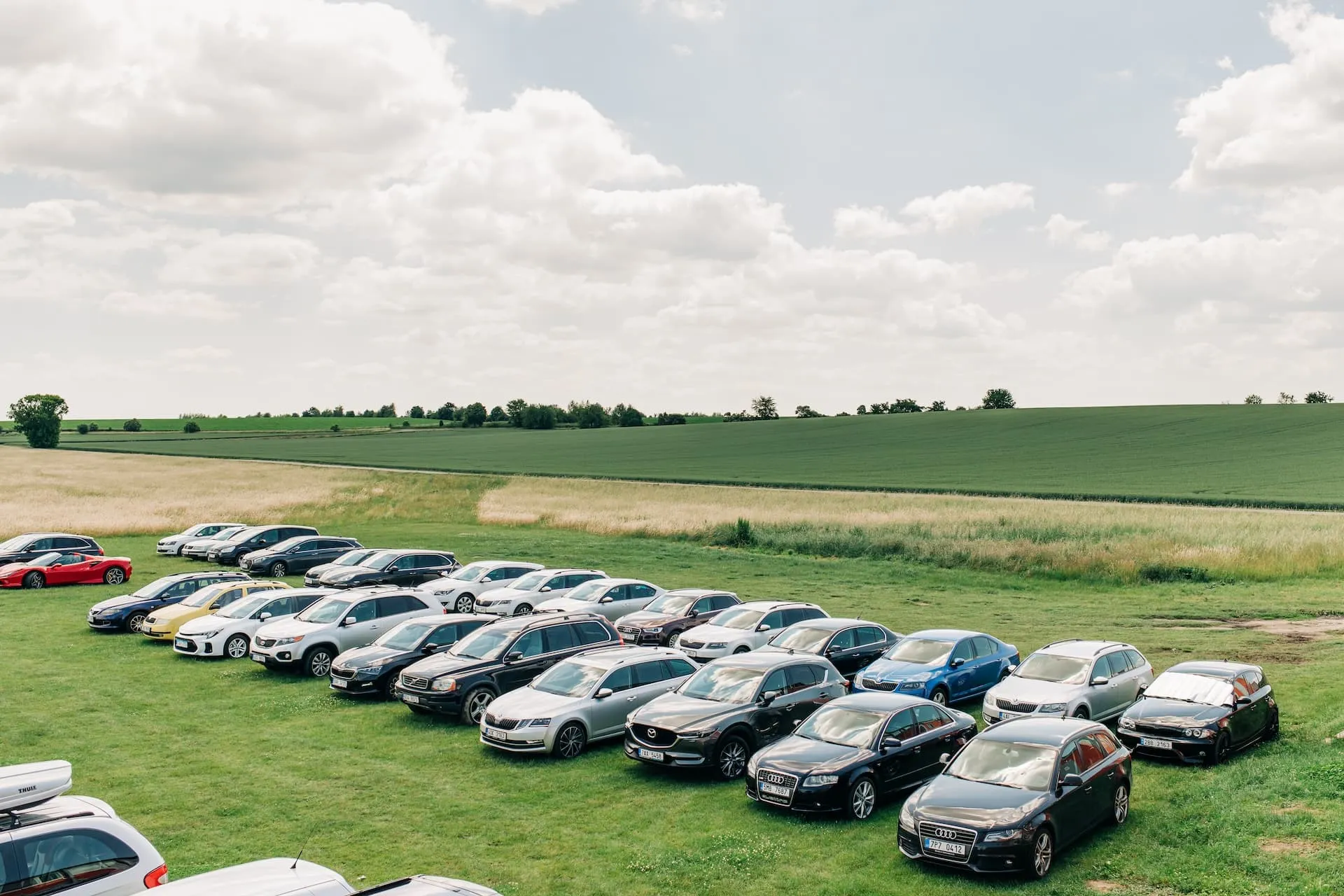 Aeródromo de Prostějov: filas de coches aparcados en el aparcamiento de hierba junto a los campos