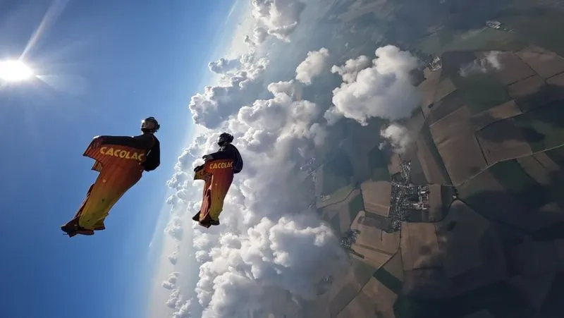 Campeonato de Europa y Copa del Mundo 2023: dos paracaidistas con wingsuits naranjas con el rótulo Cacolac sobre las nubes