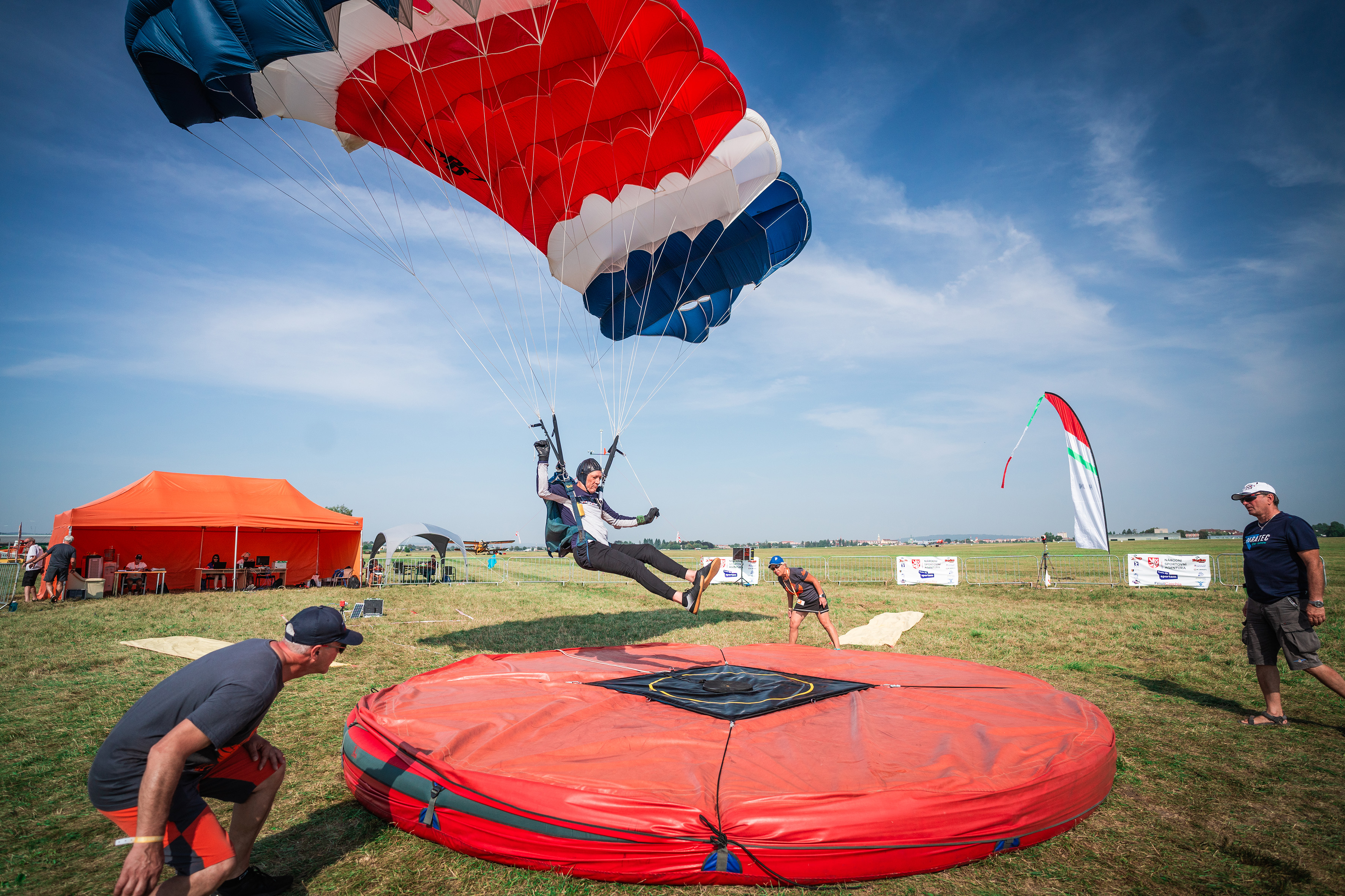 FAI World Championships 2024: competitor under a red, white and blue canopy coming in to the red accuracy landing pad