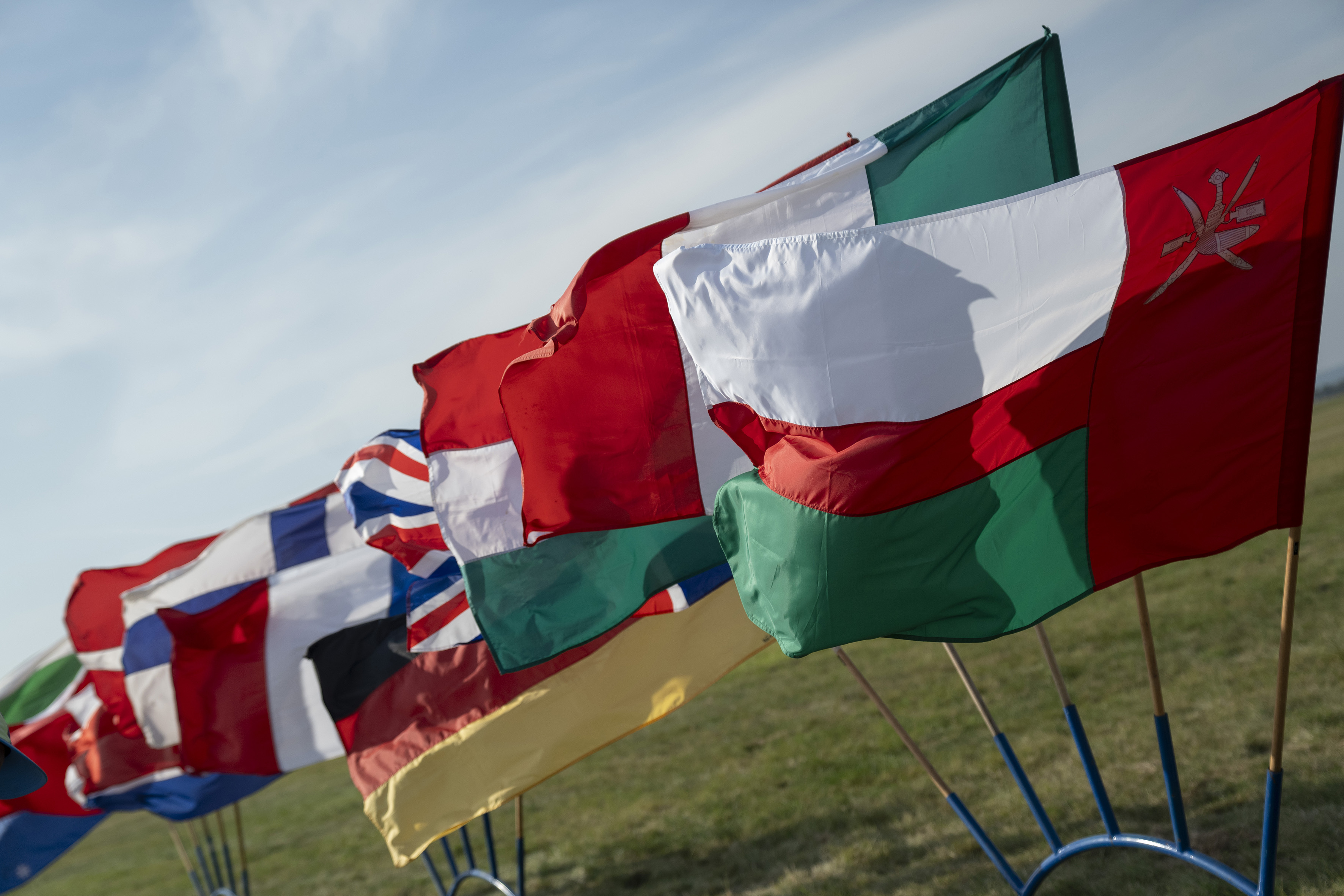 Campeonatos del Mundo FAI 2024: hilera de banderas nacionales ondeando al viento sobre la hierba, con la de Omán en primer plano