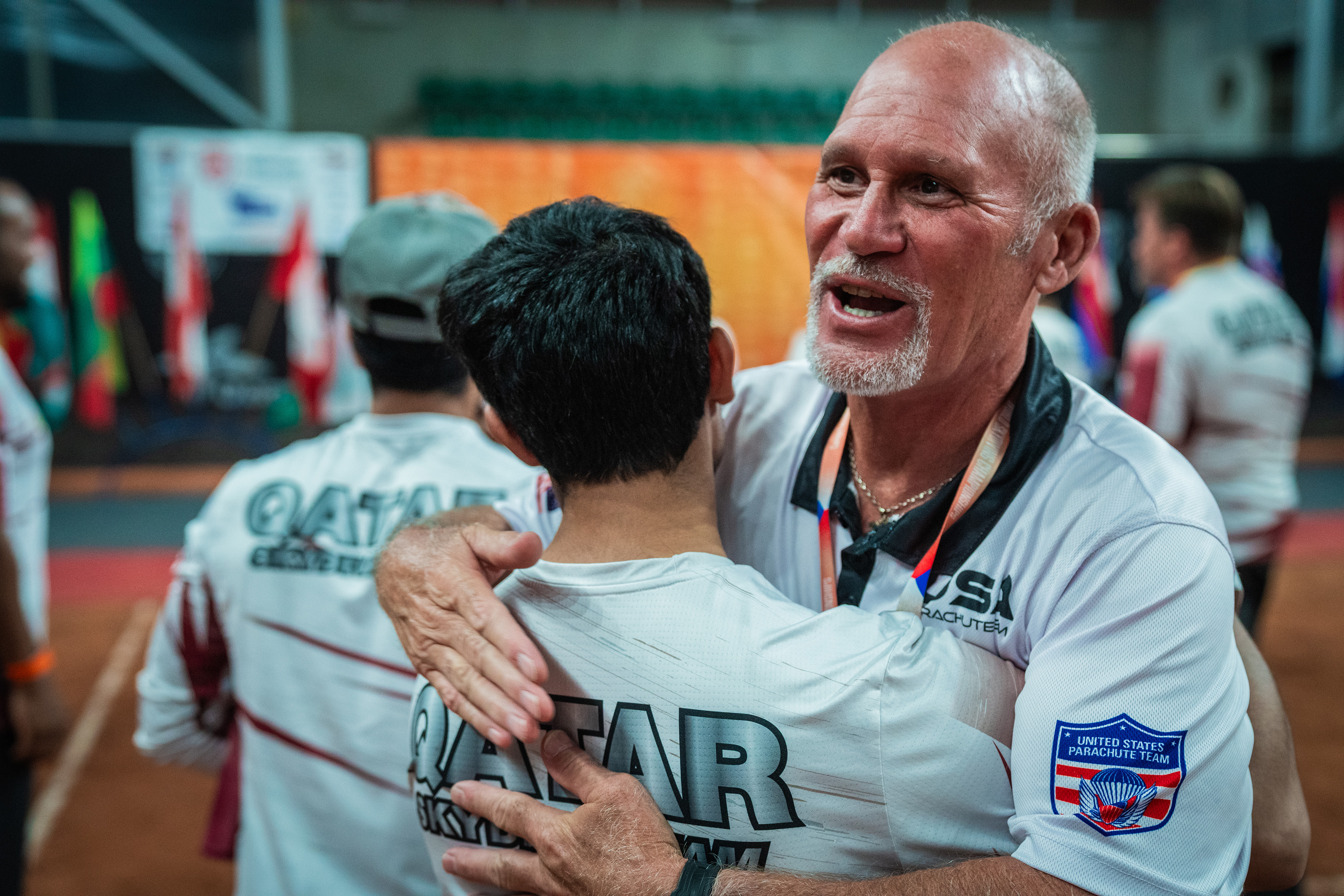 Campeonatos del Mundo FAI 2024: un miembro del United States Parachute Team abraza a un competidor con camiseta de Qatar